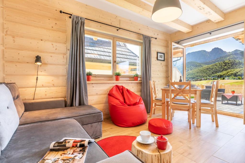 a living room with a couch and a table at Apartamenty Zobacz Giewont Zakopane in Kościelisko