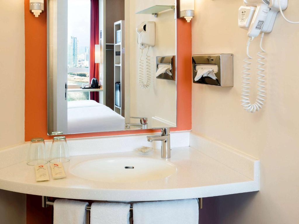 a bathroom with a sink and a mirror at Ibis Hong Kong Central & Sheung Wan in Hong Kong