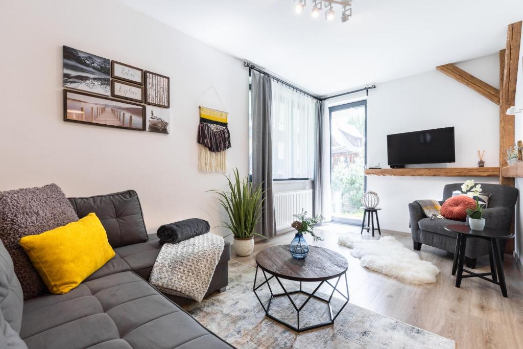 salon z kanapą i stołem w obiekcie Apartamenty Granitica Zakopane w Zakopanem