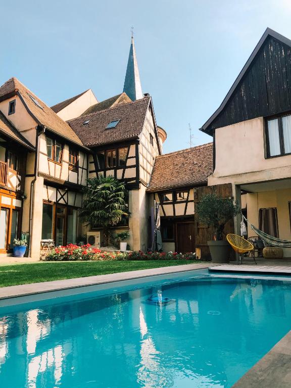 une maison avec une piscine devant une maison dans l'établissement Maison d'hôtes La Rose d'Alsace, à Rosheim