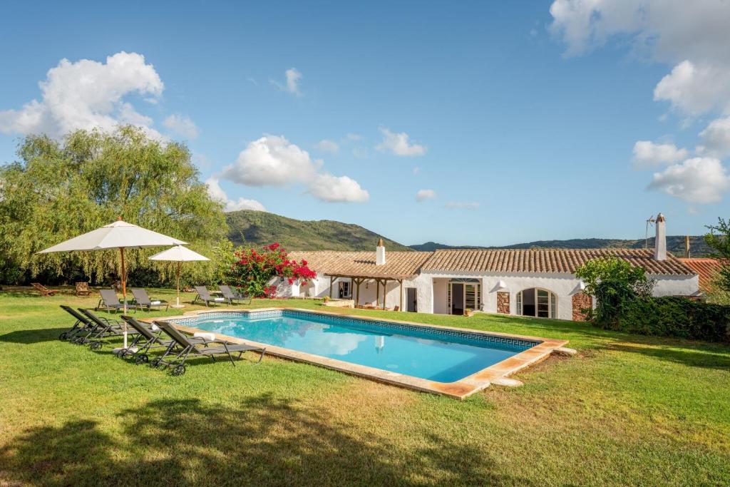 un patio trasero con piscina y una casa en Finca Estancia de Son Gras en Ferreries