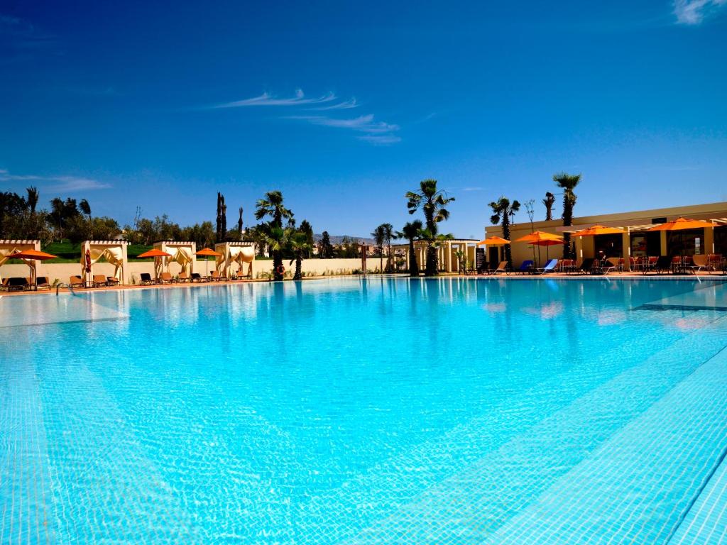 a large swimming pool with blue water in a resort at Palais Médina Riad Resort in Fès