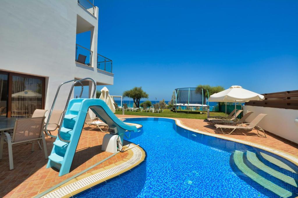 a pool with a water slide in a house at Seafront Protaras Villas in Protaras