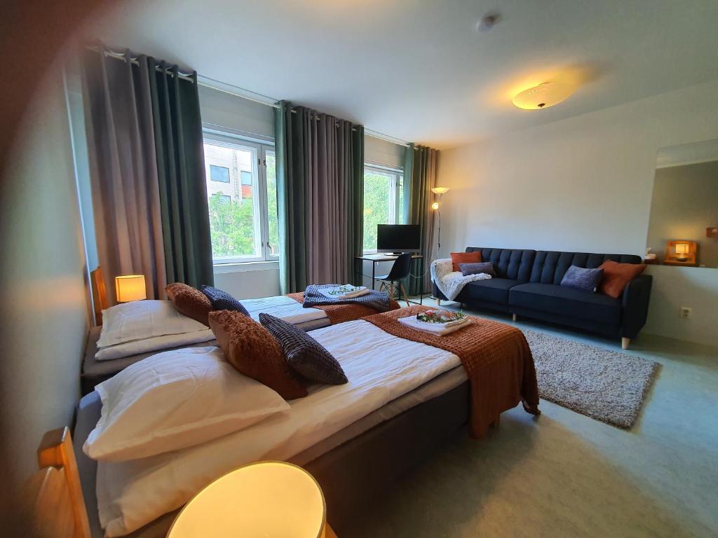 een grote slaapkamer met 2 bedden en een bank bij Hotel Kuusanka in Kuusamo