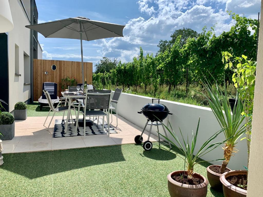 a patio with a grill and a table with a bbq at Le gîte de Ninon et Léon 2 épis in Eguisheim