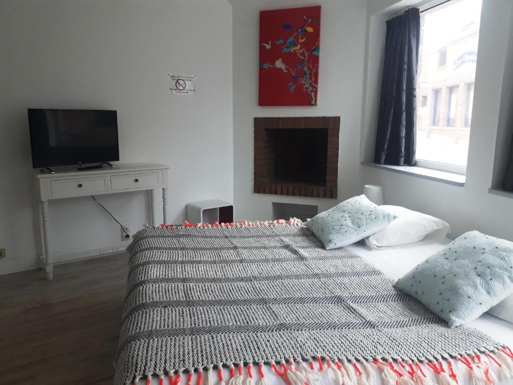 a bedroom with a bed with two pillows and a television at Hotel De L'Europe in Perros-Guirec