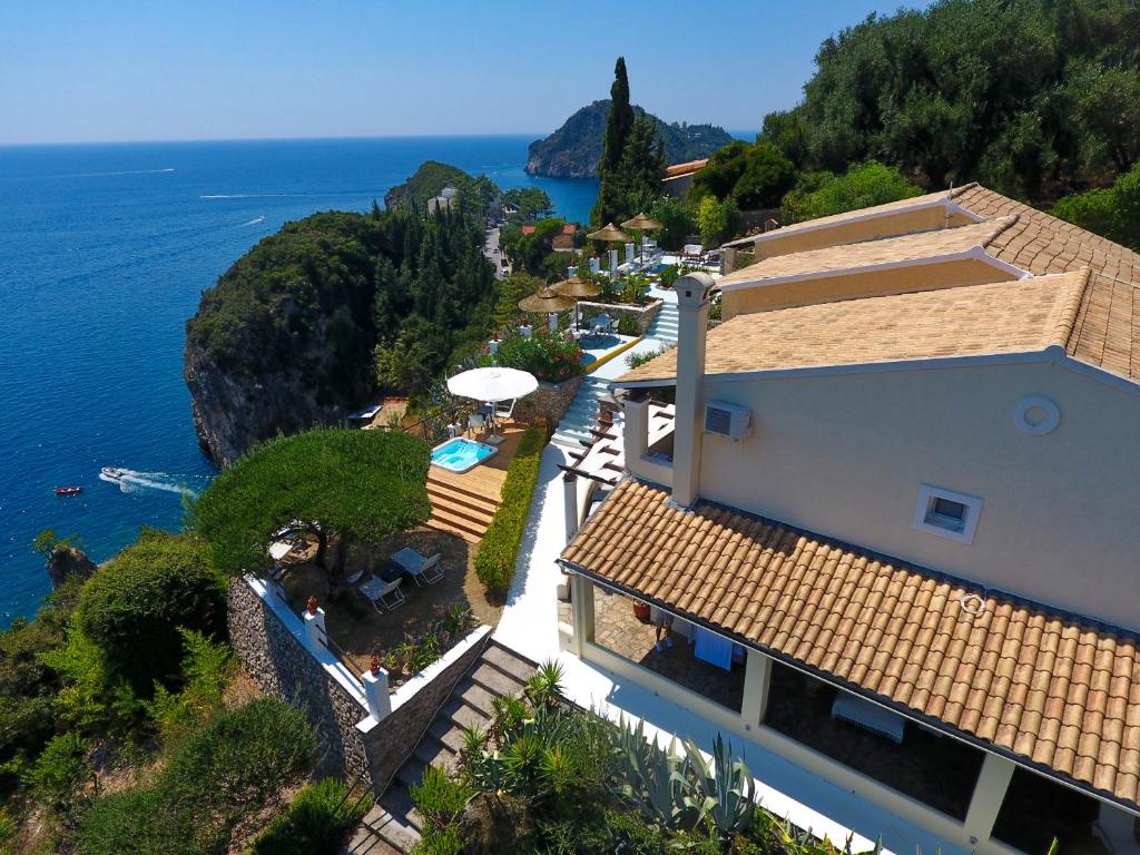 z góry widok na dom z widokiem na ocean w obiekcie Elysium Apartments Corfu w mieście Paleokastritsa