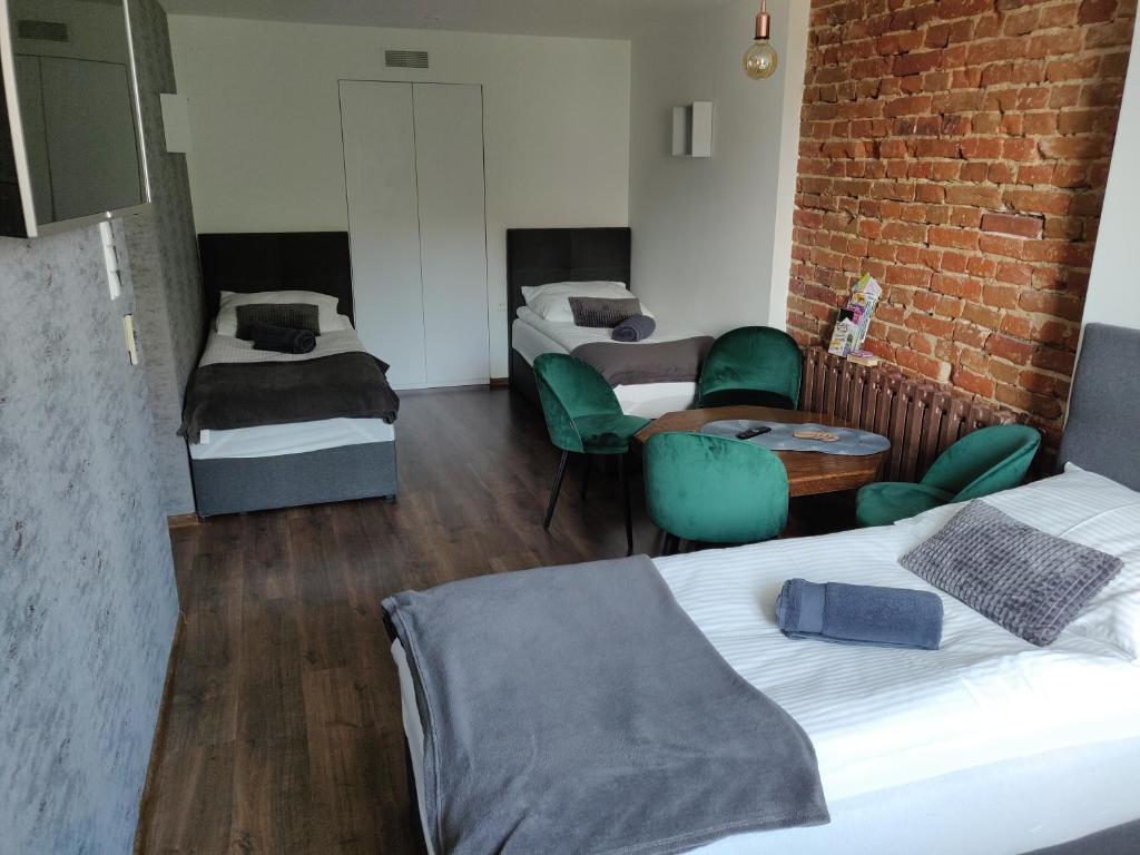 Pokój z 2 łóżkami i ceglaną ścianą w obiekcie Apartament Studio 11 Starówka Konin w Koninie