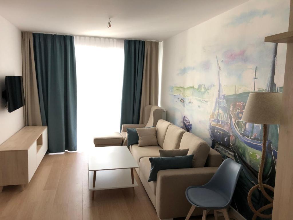 een woonkamer met een bank en een tafel bij Nadmorskie Tarasy Apartament 312 in Kołobrzeg