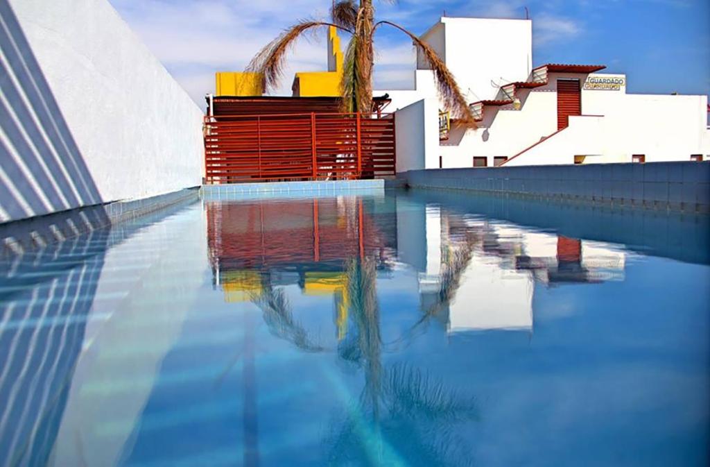 una piscina de agua frente a un edificio en INMOTEGA - Suites TG en San Luis Potosí