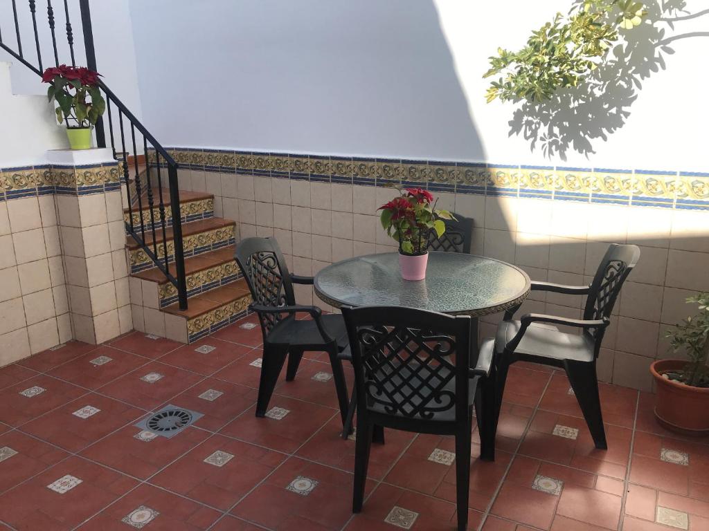 einen Tisch und Stühle in einem Zimmer mit einer Treppe in der Unterkunft Casa Mena in Nerja