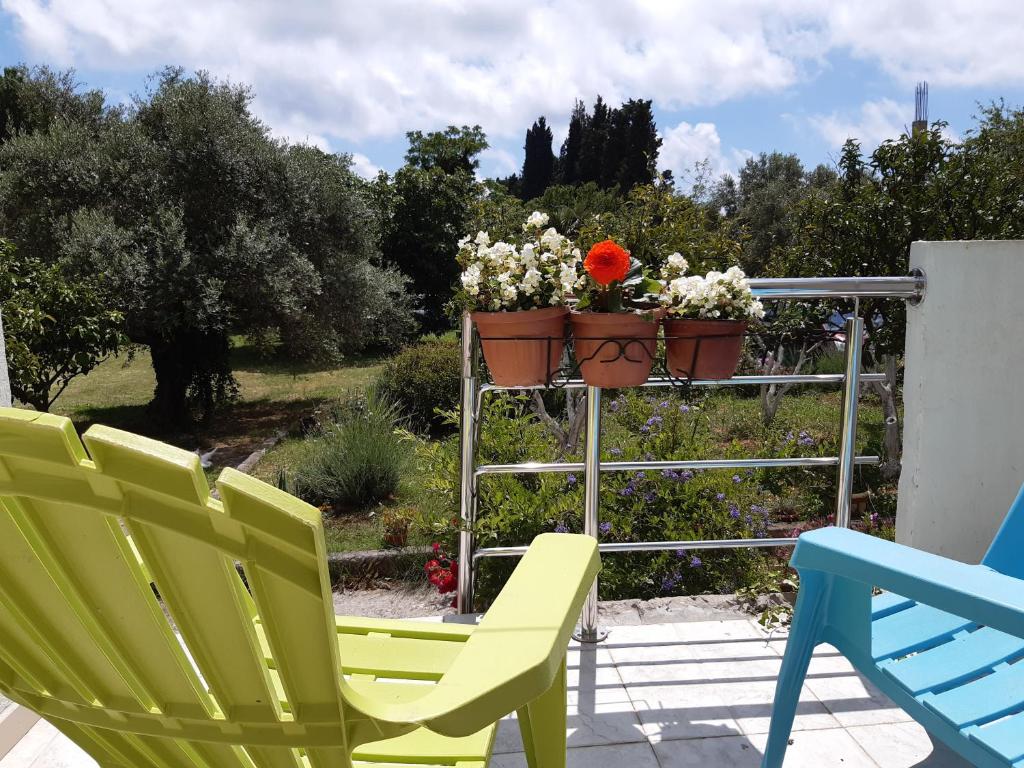 two chairs and a flower pot on a metal rack at Family apartment Garden and Sea in Petrovac na Moru