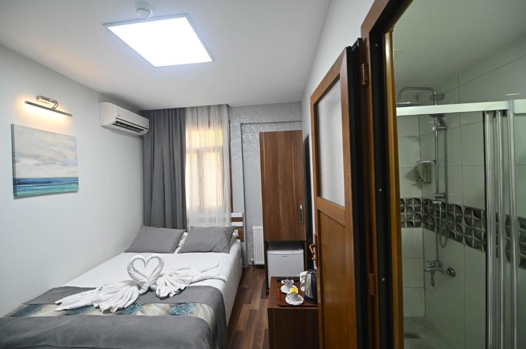 a small bedroom with a bed and a shower at Safir Gold Hotel in Istanbul