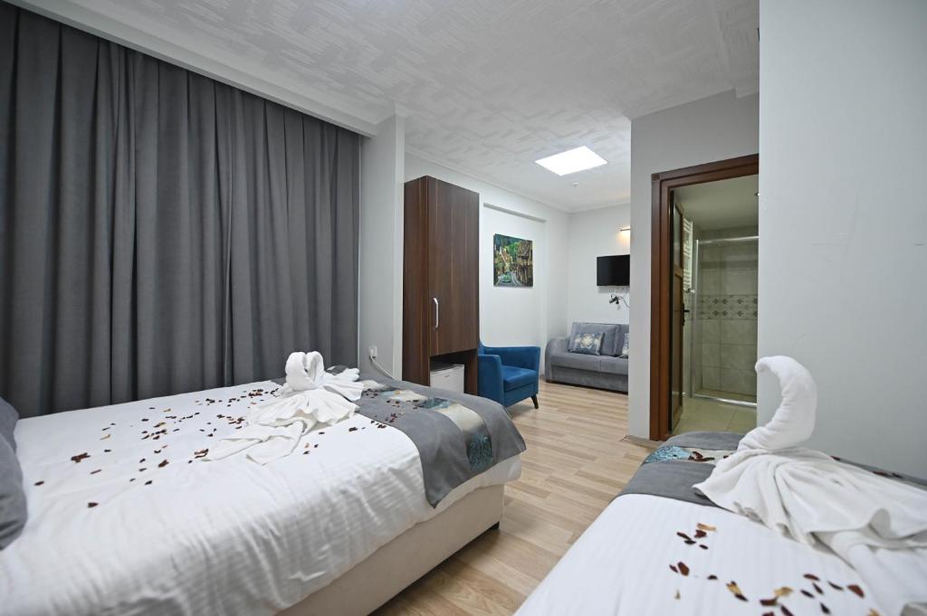イスタンブールにあるSafir Gold Hotelのベッドルーム1室(シーツに花を飾ったベッド2台付)