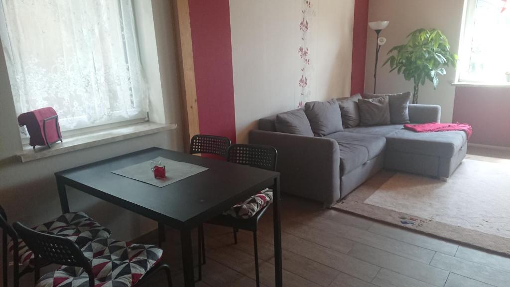 ein Wohnzimmer mit einem Sofa, einem Tisch und Stühlen in der Unterkunft FeWo Erika in Lengenfeld