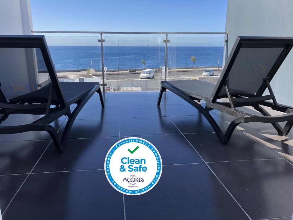 a pair of chairs and a table with a view of the ocean at Ocean house in Ponta Delgada