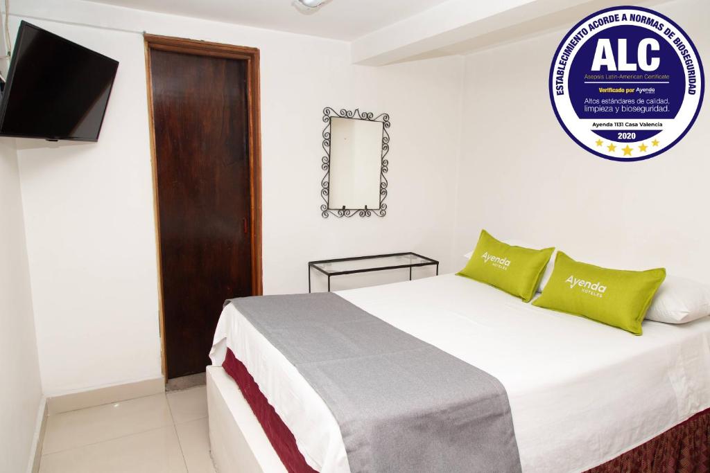 1 dormitorio con 1 cama y TV en la pared en Ayenda 1131 Casa Valencia, en Manizales
