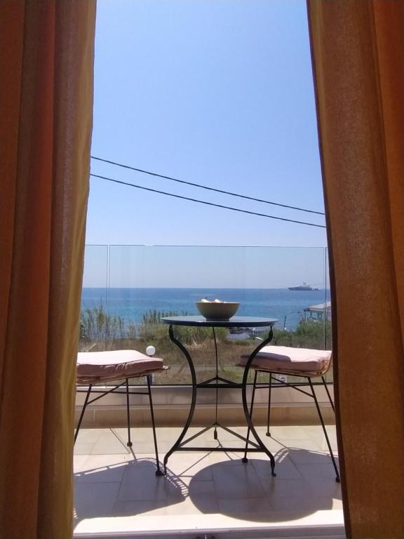 a balcony with a table and chairs and a view of the ocean at Sole Verde in Agios Georgios
