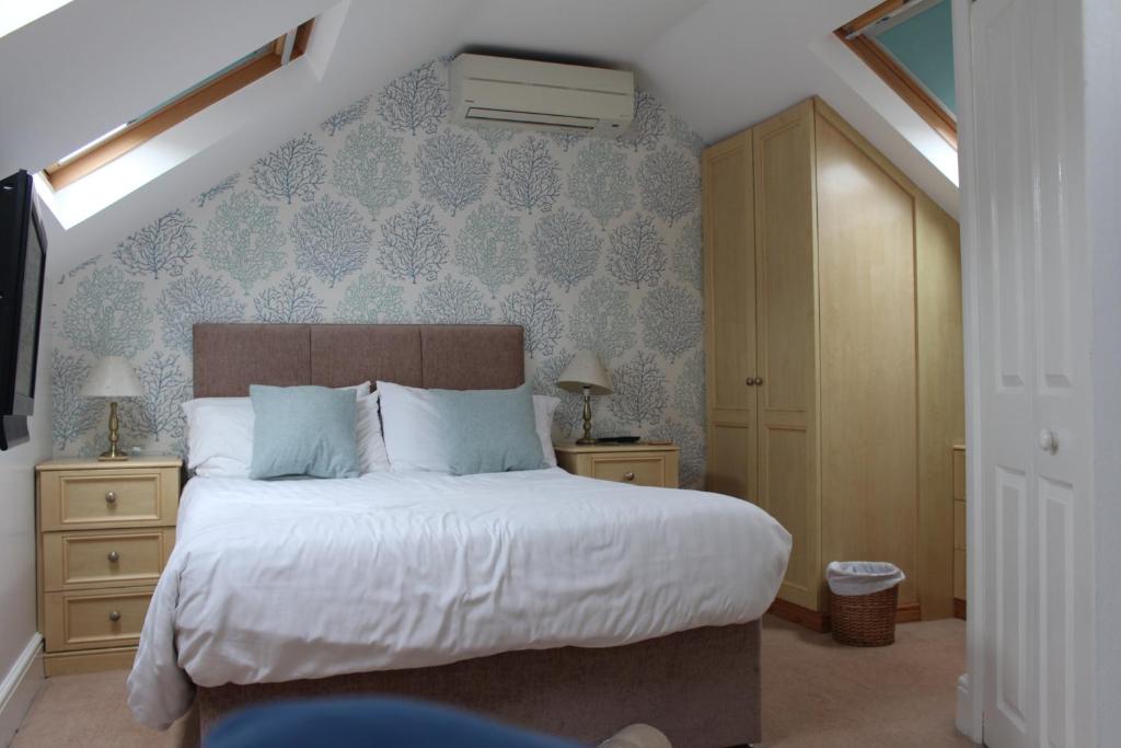 a bedroom with a large bed with blue wallpaper at Grange Lodge in York