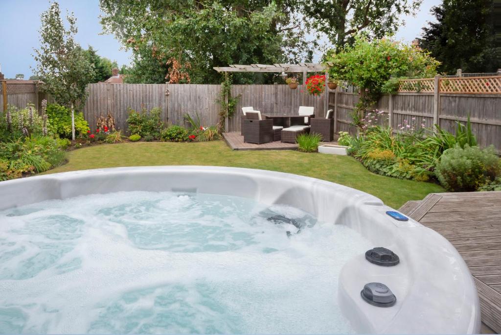 ヨークにあるWoodlea House with Hot tubのパティオ付きの庭にジャクジータブが備わります。