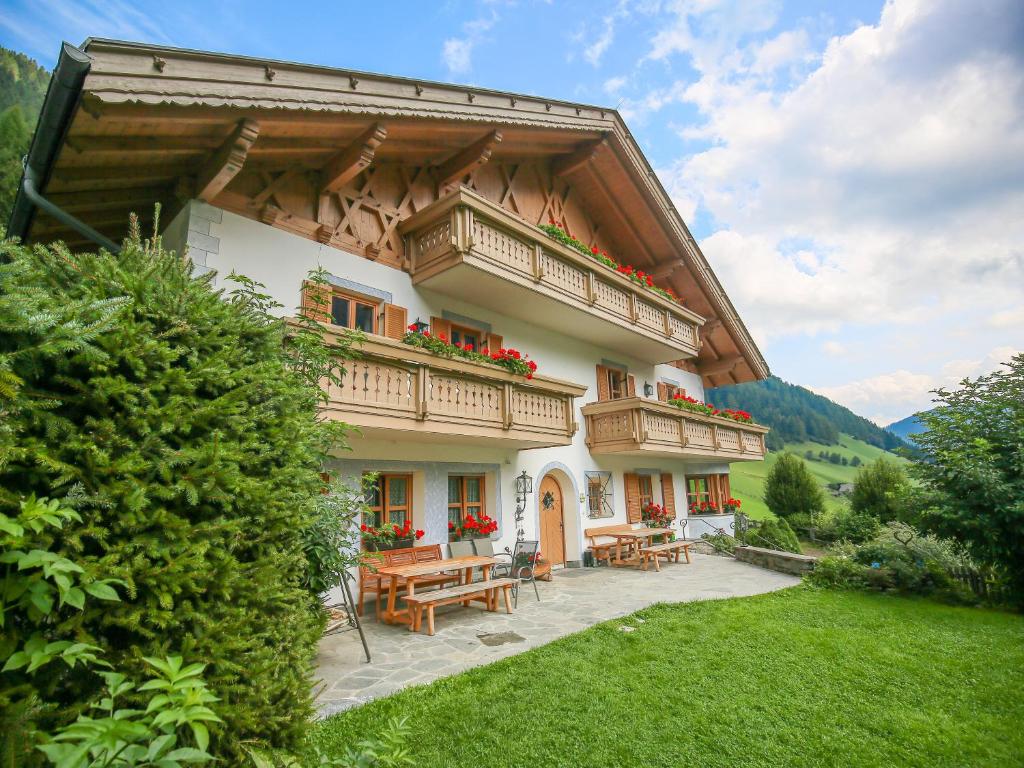 ein Haus mit einem Balkon und einem Holztisch in der Unterkunft Maurerhof in Ratschings