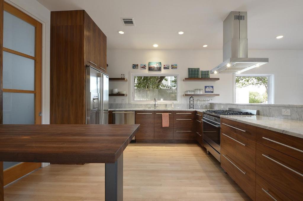 a large kitchen with wooden cabinets and a wooden table at Park Lane Modern in Austin