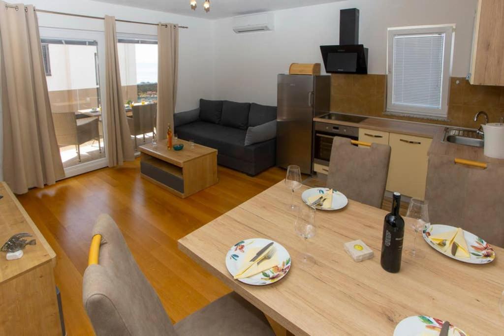 a kitchen and living room with a table with plates on it at Apartments Vladimir #3 in Makarska