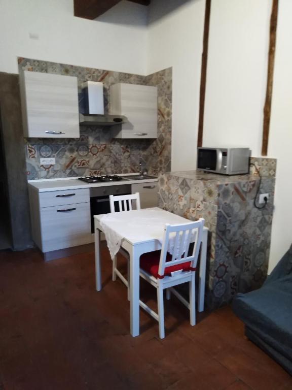 a small kitchen with a white table and two chairs at Casa Dante in Vitorchiano