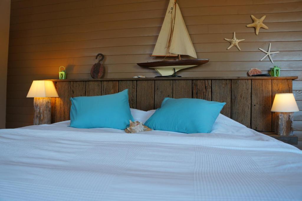 ein Teddybär auf einem Bett mit blauen Kissen in der Unterkunft B&B Oesterhoeve in Ostende