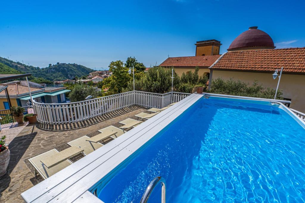 a swimming pool with chairs and a house at Villa Celentano in Vico Equense