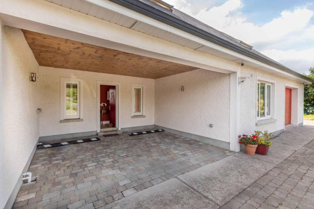 a large white house with a large patio at The Jerpoint Apartment in Thomastown