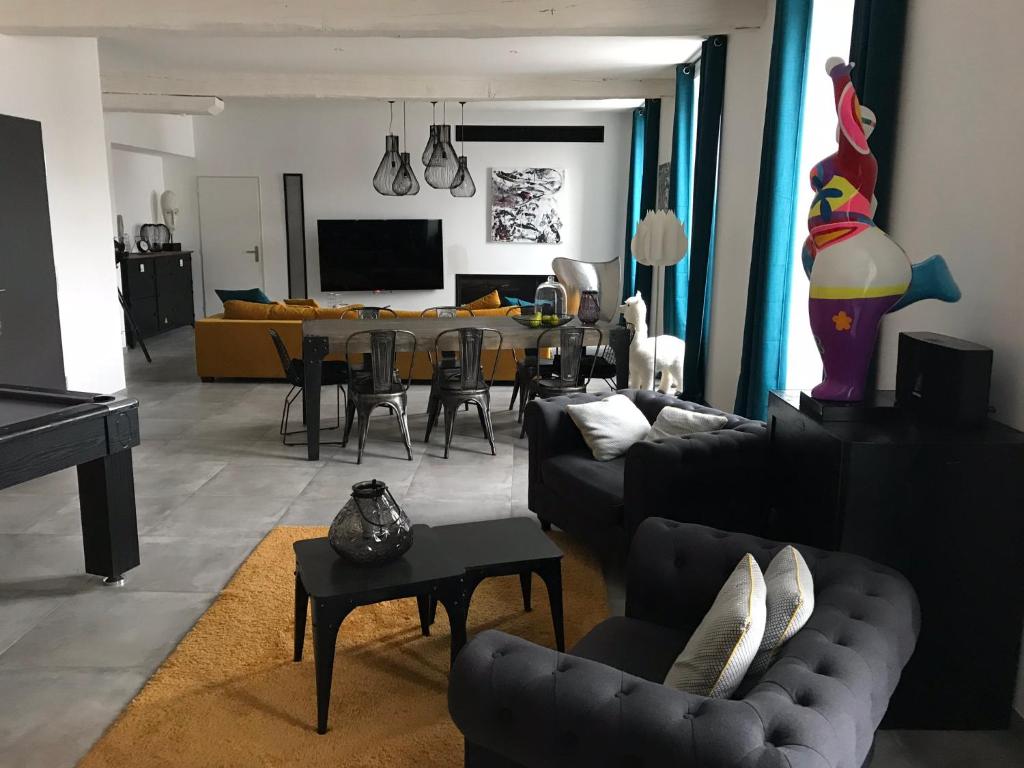 uma sala de estar com um sofá e uma sala de jantar em Les remparts em Semur-en-Auxois