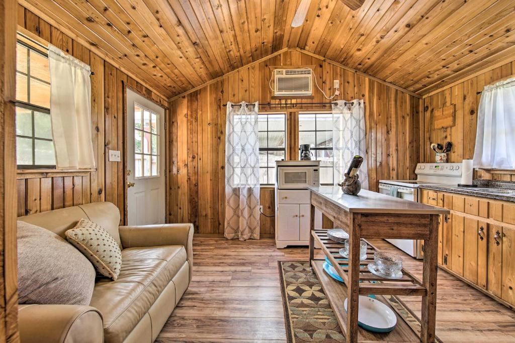 sala de estar con sofá y mesa en la cocina en Couples Cabin with Luxury Deck, 1 Mi to Canyon Lake! en Canyon Lake