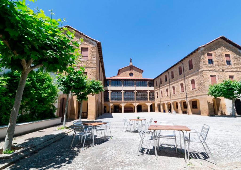 a courtyard with tables and chairs in front of a building at Hospedería Bei.tu in Beire