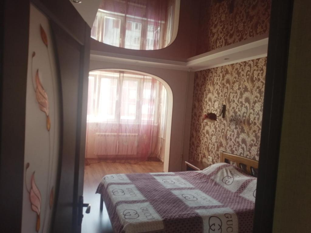 a small bedroom with a bed and a window at Здається подобово 3кімнатна квартира з wifi i екслюзивним ремонтом,є кімната гардероб,спальня і кімната,санвузол і ванна також парковочне місце in Chernivtsi