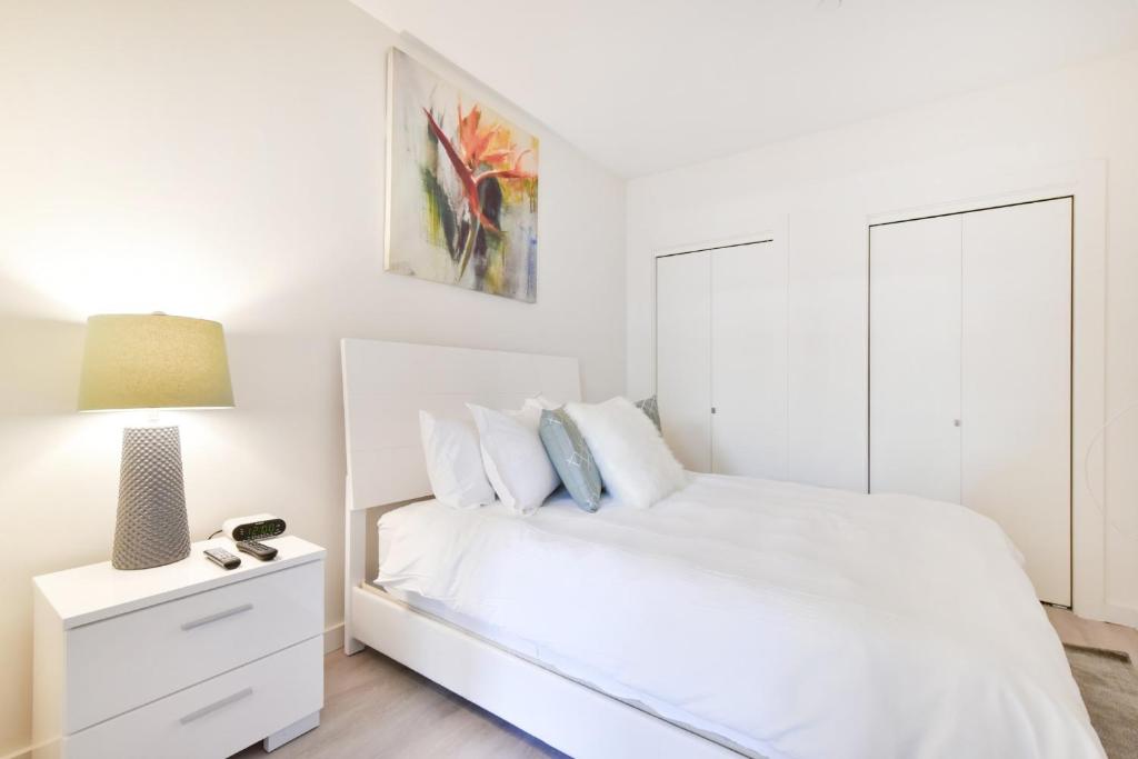 una camera da letto bianca con un letto bianco e una lampada di Global Luxury Suites Downtown Boston a Boston
