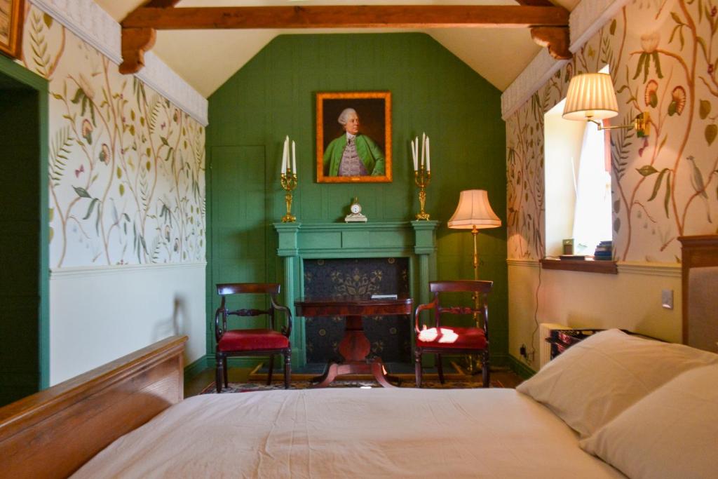 a green bedroom with a bed and a fireplace at The Munches Room at Buittle Castle in Castle Douglas