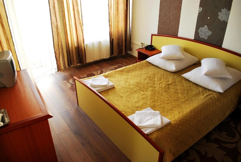 1 dormitorio con 1 cama grande y 2 almohadas en Vila Meteor, en Cluj-Napoca
