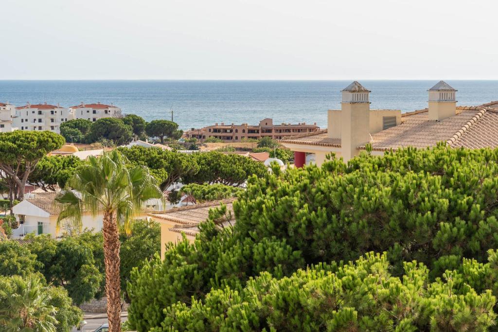 uma vista para uma cidade com árvores e o oceano em Vista das Ondas 308 em Albufeira