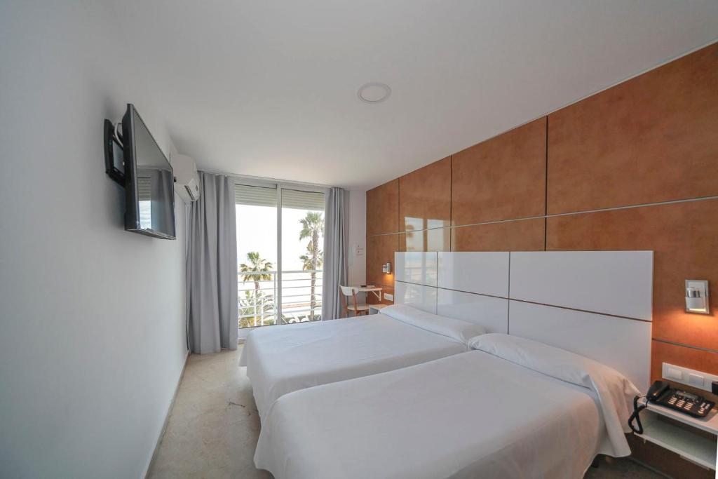 a hotel room with a white bed and white walls at Sol Playa in Valencia