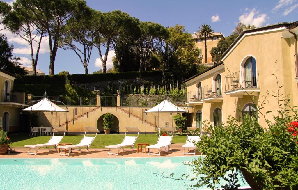 una piscina con sillas y sombrillas junto a una casa en Villa Agnese en Sestri Levante
