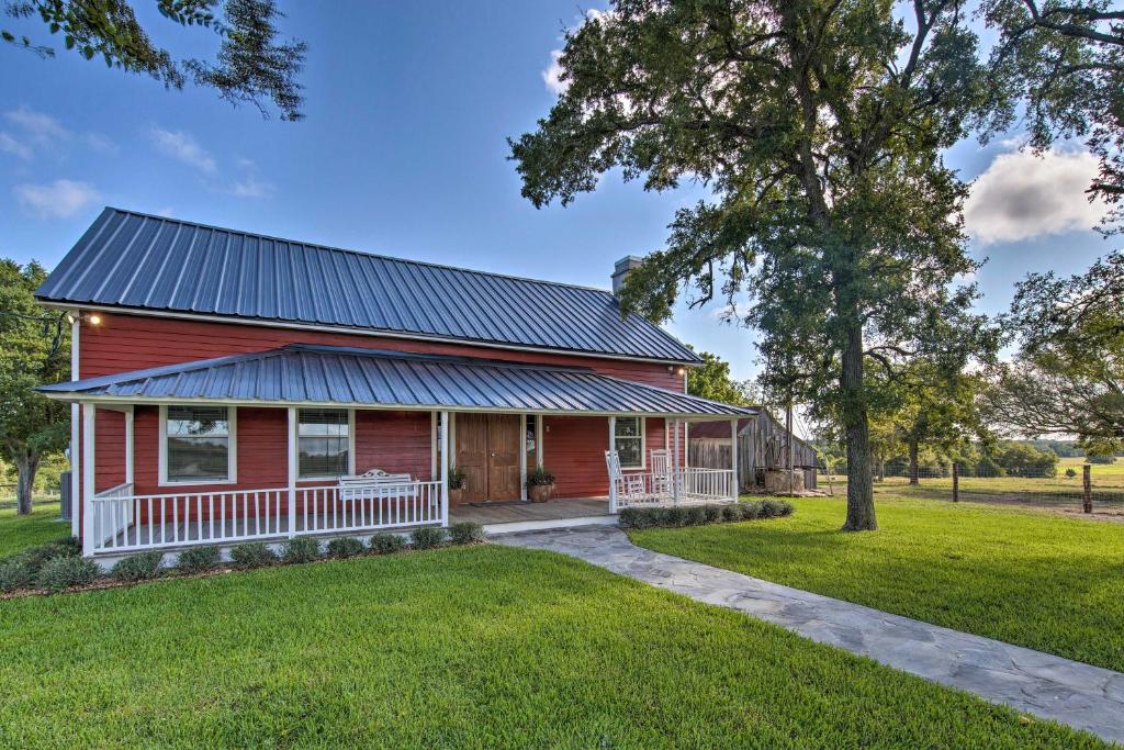 uma casa vermelha com um telhado de metal em Chic Farmhouse - Wine Tasting and Church Tour! em Schulenburg