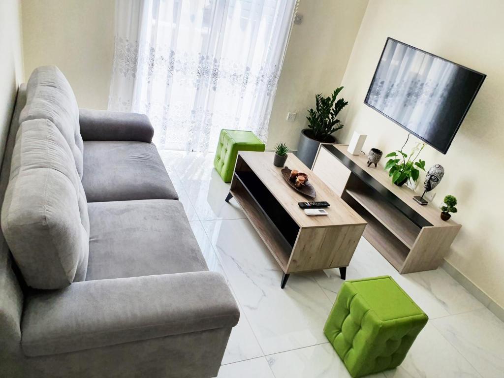ein Wohnzimmer mit einem Sofa und einem TV in der Unterkunft 2 Bedroom Cozy Apartment near Tourist Area, 200m from sea in Paphos