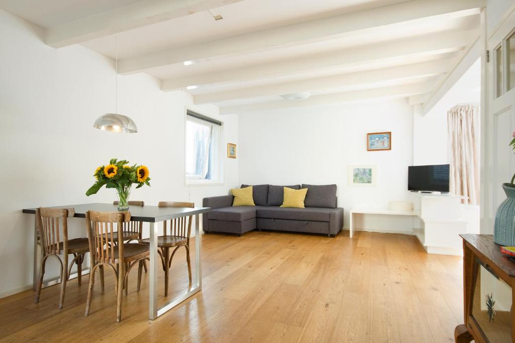 a living room with a table and chairs and a couch at Green Alley Studio in Amsterdam