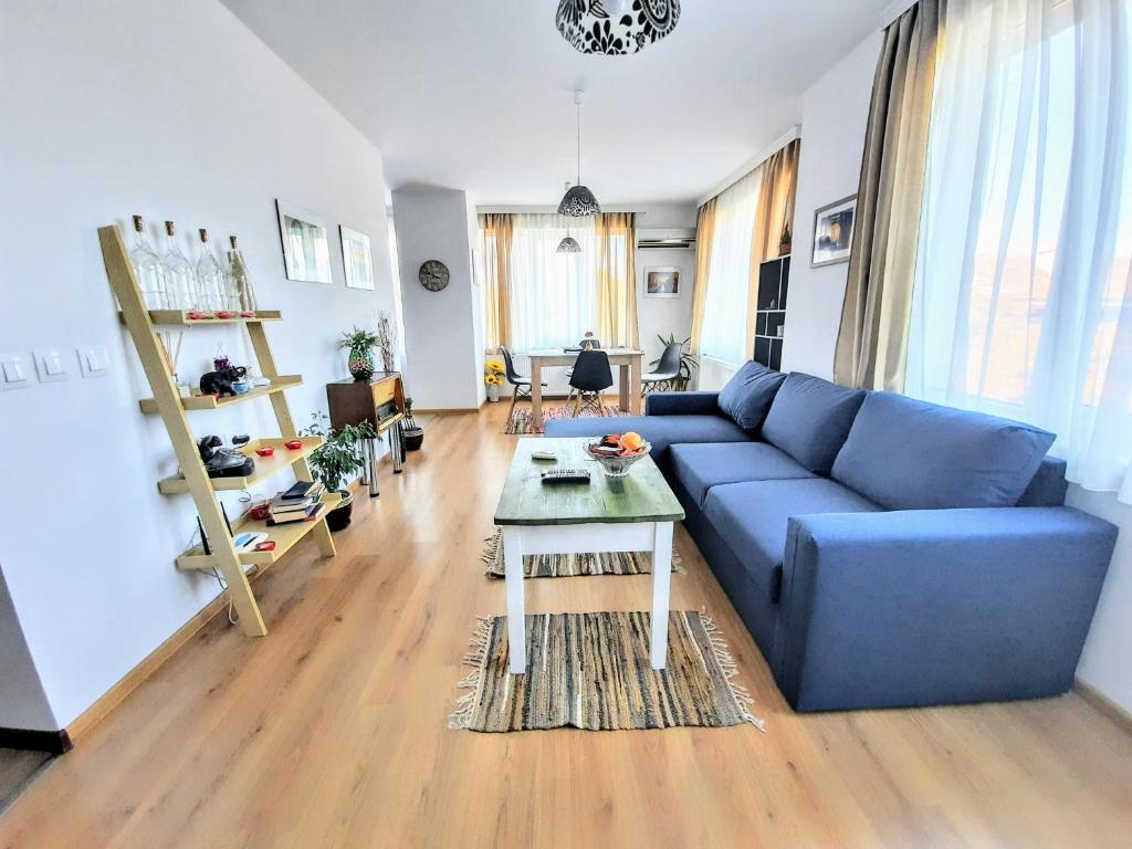 sala de estar con sofá azul y mesa en NC Apartment Ruse en Ruse