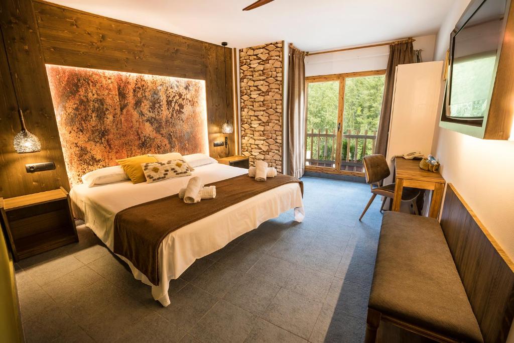 een slaapkamer met een bed en een groot raam bij Hotel Restaurant Les Brases in Sort