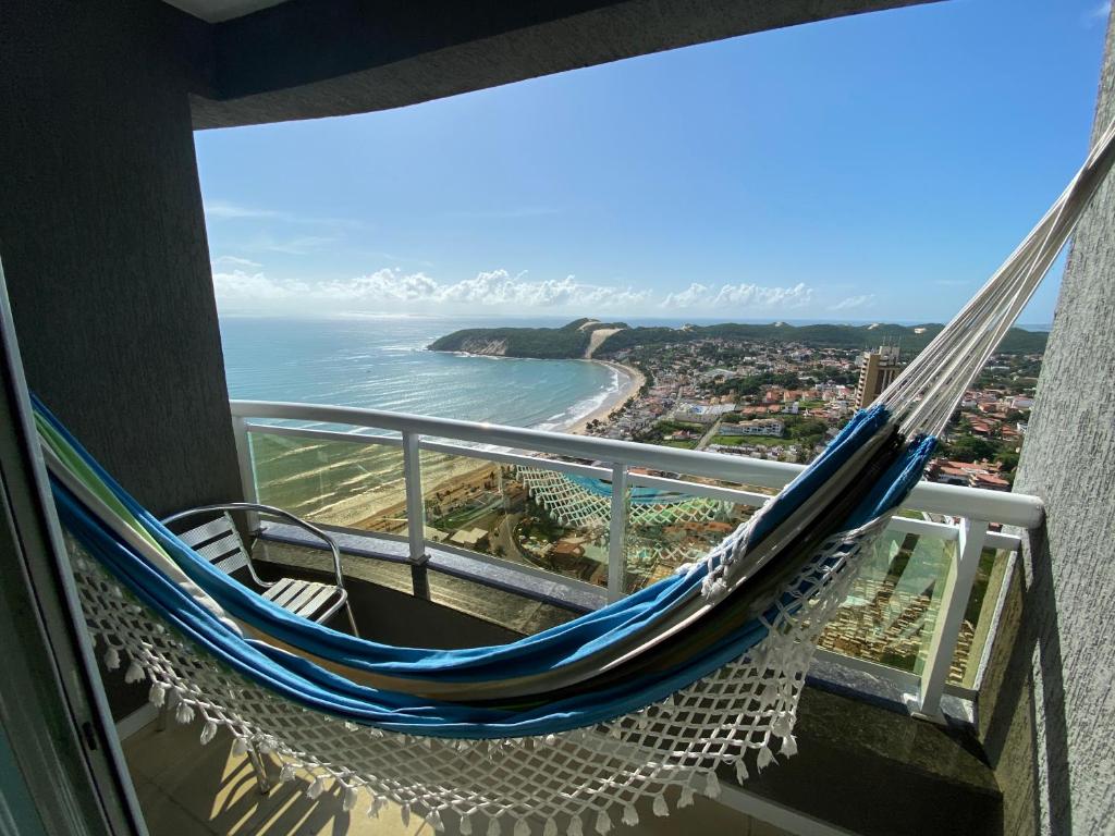 a hammock on a balcony overlooking the ocean at Blue Ocean Ponta Negra in Natal