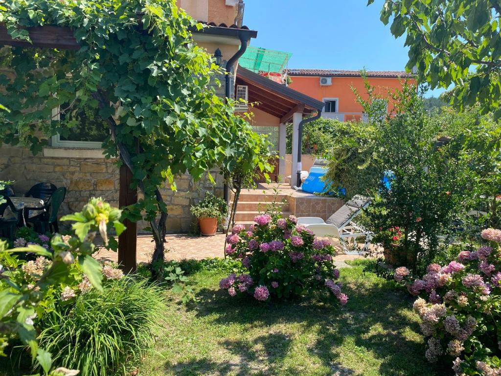 a garden with flowers and trees and a house at Apartment Villa Istriana in Koper