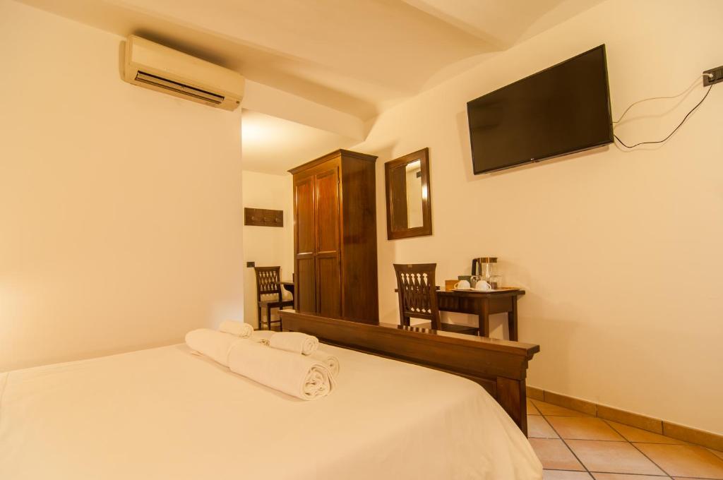 1 dormitorio con 1 cama y TV en la pared en Umbrian Concierge - Alla Rocca, en Perugia