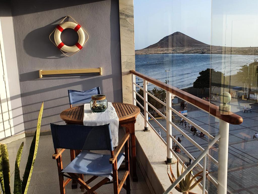 エル・メダノにあるCentro Médano Playa Grandeの山の景色を望むバルコニー(テーブル、椅子付)